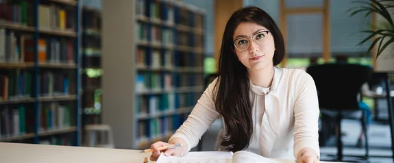 Der Studiengang Management (B. Sc.) ist mehr als nur ein BWL-Studium (Foto: UW/H | Johannes Buldmann) Eine Management Bachelor Studentin lernt in der Bibliothek