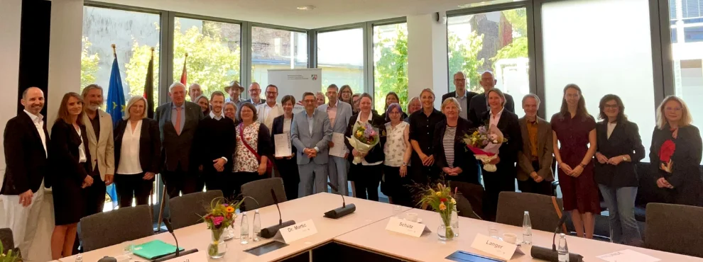 There are a lot of people standing next to each other, all of them officials from the political sphere and the Holzkamp and Otto Schott comprehensive schools.