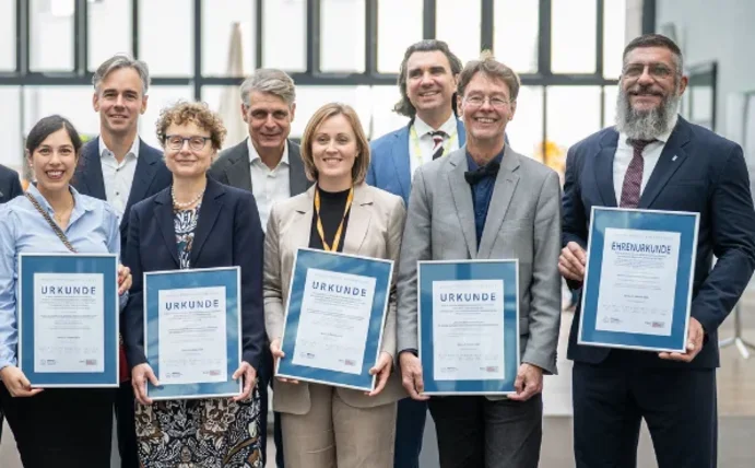 Gruppenfoto von Menschen, die Urkunden in die Kamera halten