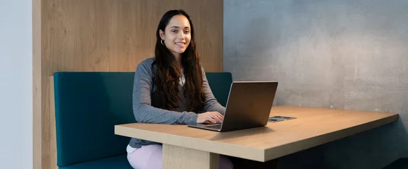 Eine Studentin sitzt am Laptop in der Bibliothek.