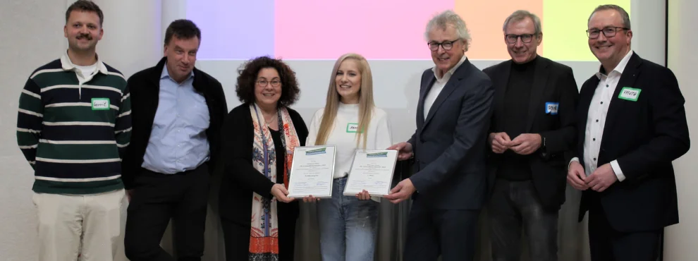 Sieben Personen lächeln in die Kamera.