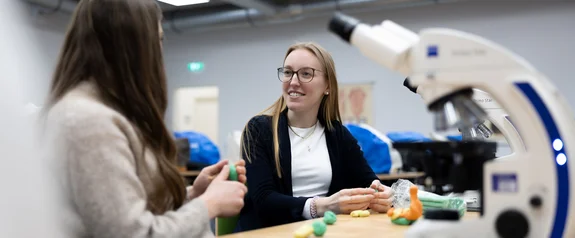 Two students at the table with microscope