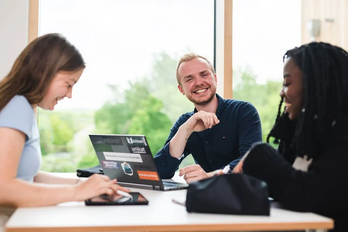 Die Lernflure bieten genügend Platz (Foto: UW/H | Johannes Buldmann) Zwei Studentinnen und ein Student sitzen im Lernflur und arbeiten zusammen am Laptop.