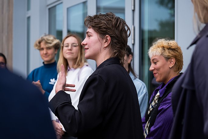 Together, the groups developed different practical approaches. (Photo: UW/H | Klara Schmickler) One person stands in a small group and speaks.