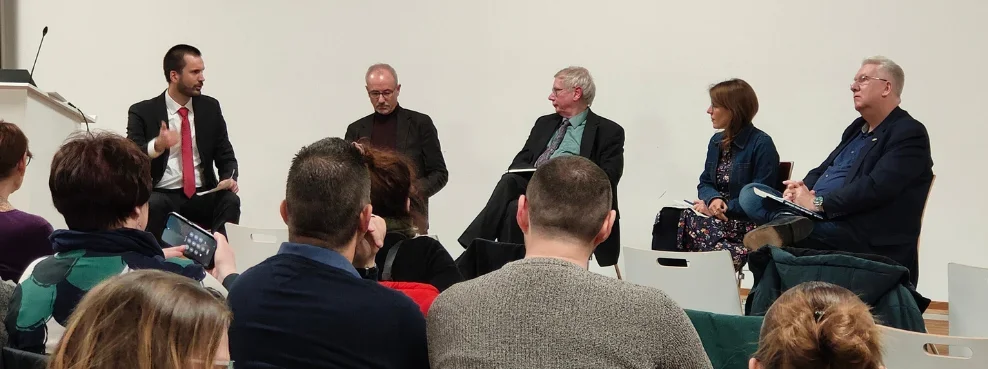 Fünf Personen sitzen nebeneinander und diskutieren.