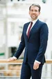 Prof. Dr. Erik Strauß (Foto: UW/H) Ein Mann im Anzug steht in der Universität und lächelt in die Kamera.