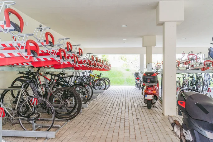 Bicycle garage at the UW/H campus (Photo: UW/H | Johannes Buldmann) View of the university's bicycle garage. Bicycles are stored here in metal racks on two levels. There are also two scooters on the right-hand side of the picture.