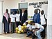 Gruppenfoto von neun Männern vor dem Gebäude der Jordan Dental Clinic.