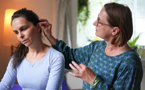 Women’s Health Symposium (Photo: Private | Trevor Johnson) A woman is inserting acupuncture needles into another woman’s ear.