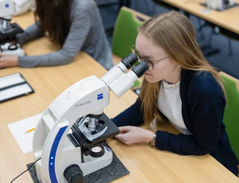 Biomedical topics take center stage at the ZBAF. (Photo: UW/H | Michael Schwettmann) Student looks through a microscope