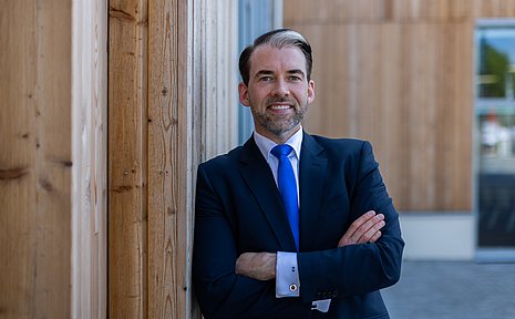 Portrait eines Mannes vor einer Holzfasade 