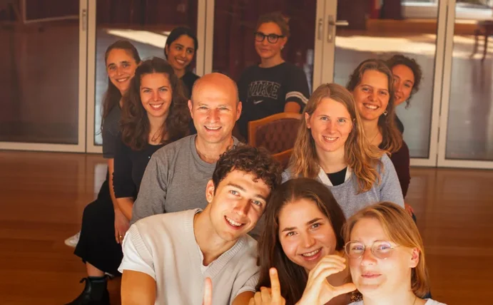 Gruppenbild der ersten LIC-Kohorte. Sie sitzen hintereinander auf Stühlen.