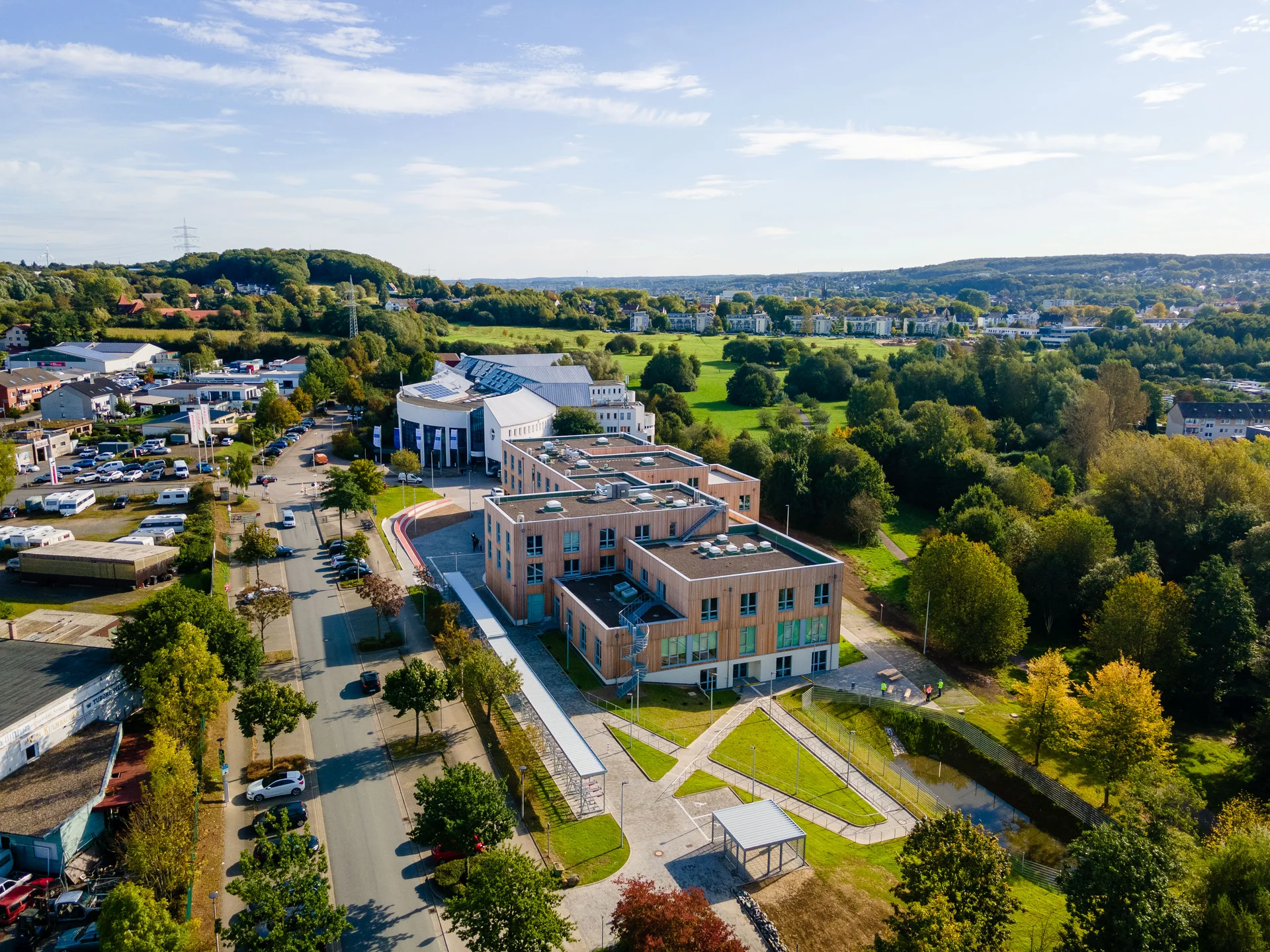 Luftaufnahme von zwei Universitätsgebäuden, die mitten im Grünen liegen.