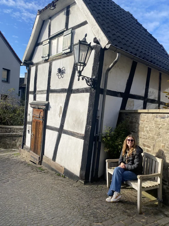 Carlotta has already discovered the most important spots in Witten and the Ruhr region. (Photo: private) Carlotta Fehrmann sits in front of a half-timbered house.