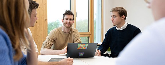 Management im Gesundheitswesen studieren an der UW/H (Foto: UW/H | Michael Schwettmann) Fünf Studierende der UW/H sitzen am Tisch und arbeiten gemeinsam.