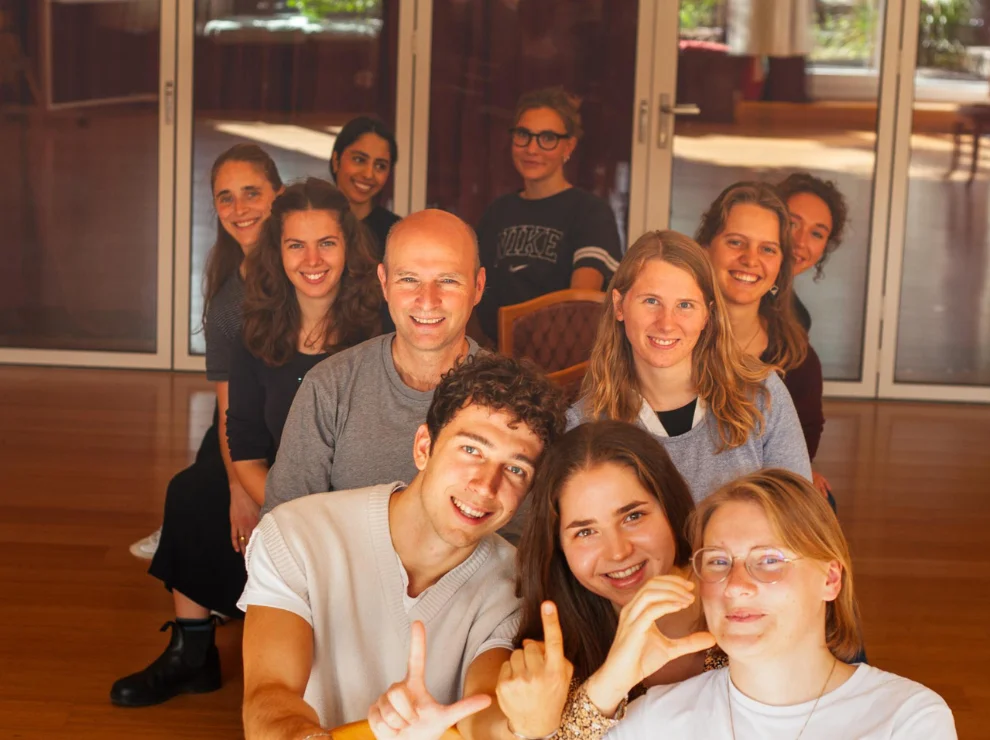 Gruppenbild der ersten LIC-Kohorte. Sie sitzen hintereinander auf Stühlen.