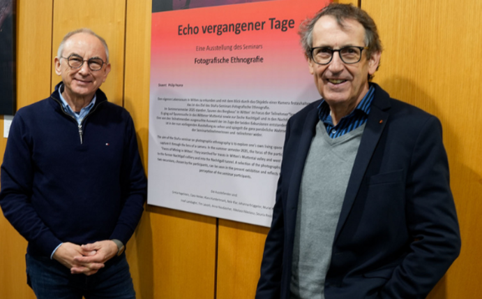 Eine neue Ausstellung in der Zahnklinik der UW/H zeigt Fotografien von Studierenden. (Foto: UW/H | Kristina Eichhorn) Fotokünstler Philip Pearce und Prof. Dr. Stefan Zimmer stehen vor dem Titelbild der Ausstellung.