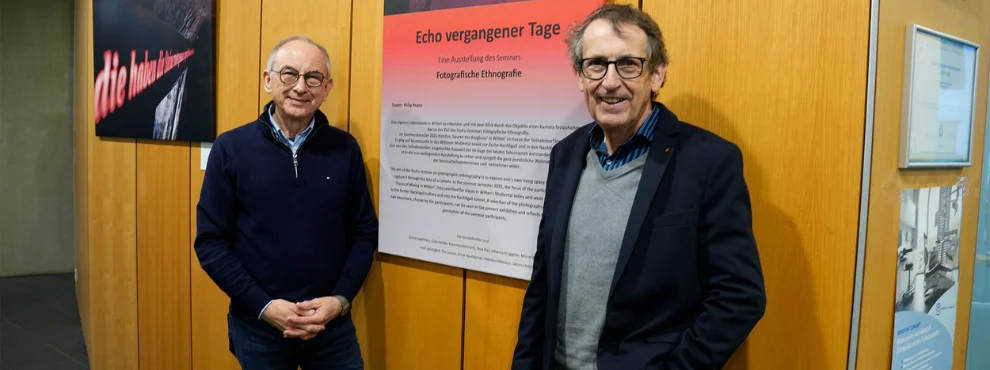 Fotokünstler Philip Pearce und Prof. Dr. Stefan Zimmer stehen vor dem Titelbild der Ausstellung.
