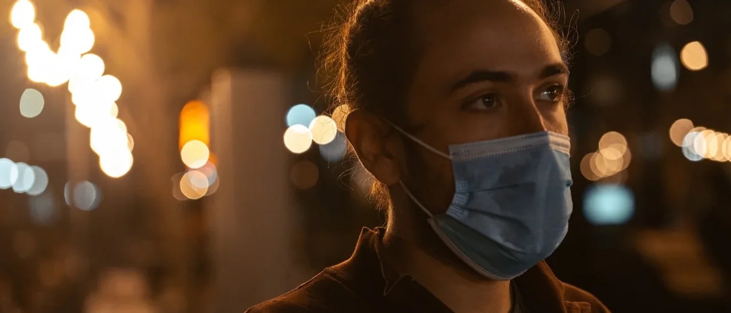 Ein junger Mann trägt eine OP-Maske.