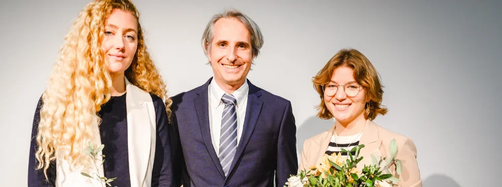 Drei Personen lächeln in die Kamera.