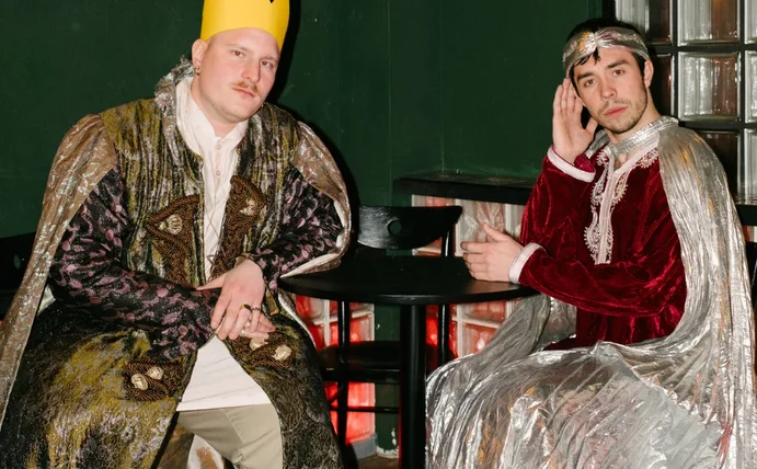 Julian Seitlinger und sein Geschäftspartner sitzen als Könige verkleidet an einem Tisch.