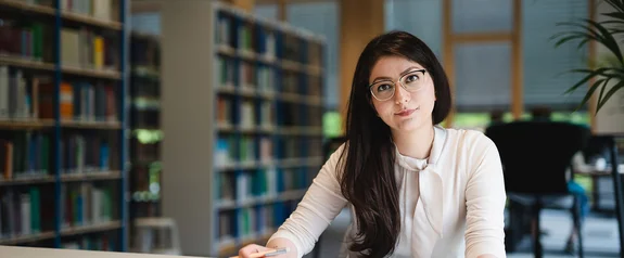 Der Studiengang Management (B. Sc.) ist mehr als nur ein BWL-Studium (Foto: UW/H | Johannes Buldmann) Eine Management Bachelor Studentin lernt in der Bibliothek
