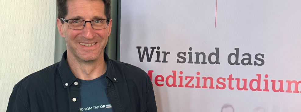 Dr Till Bachmann, anaesthetist from the Helios University Hospital Wuppertal at UW/H, has completed his Master of Medical Education (MME). A man with a certificate in his hand smiles at the camera.