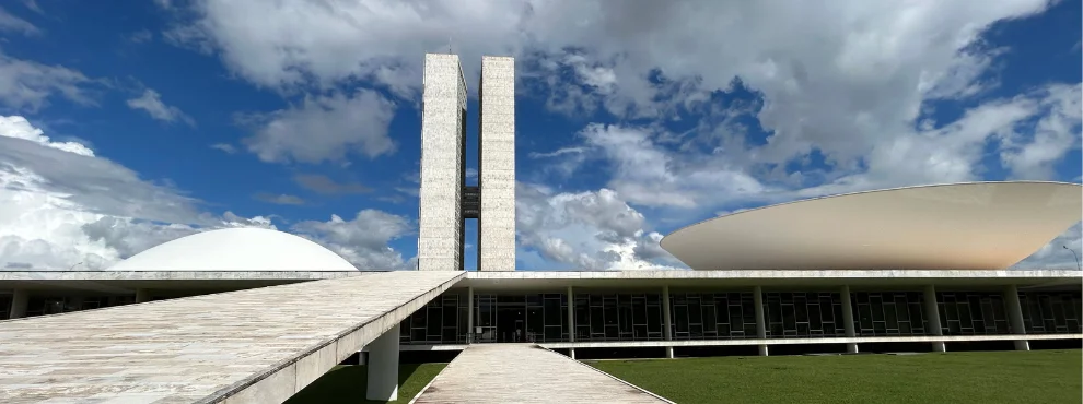 The photograph shows the Brazilian Parliament, with its distinctive twin towers and the dome on the roof