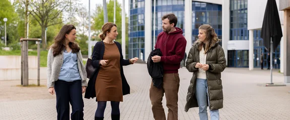 Professorin und Studierende führen offene Pausengespräche auf dem Außengelände