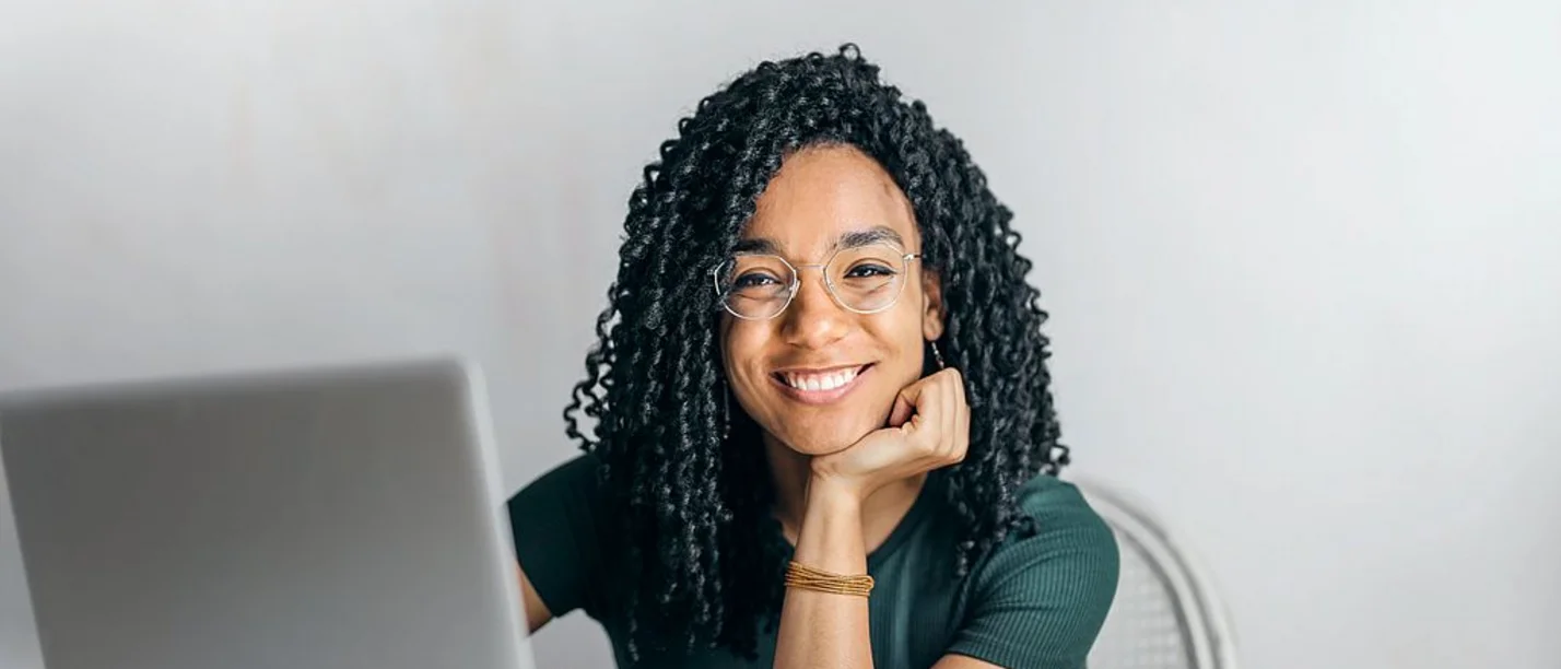 In unseren Online-Schnupperseminaren bekommen Studieninteressierte einen Einblick in das Psychologie-Studium an der UW/H. (Foto: pexels | Andrea Piacquadio) Eine junge Frau sitzt vor einem Laptop und lächelt in die Kamera.