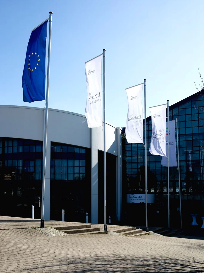 Haupteingang mit Fahnenmasten der Universität Witten/Herdecke