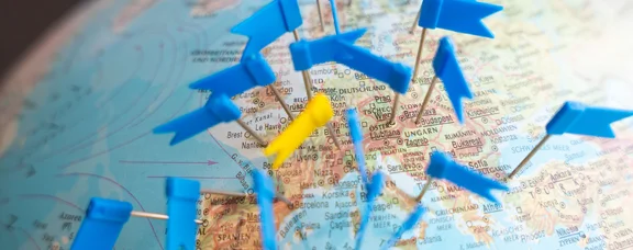 Our partner universities are located all over the world (Photo: UW/H | Kristina Eichhorn) A close-up of a globe with flags stuck into it.