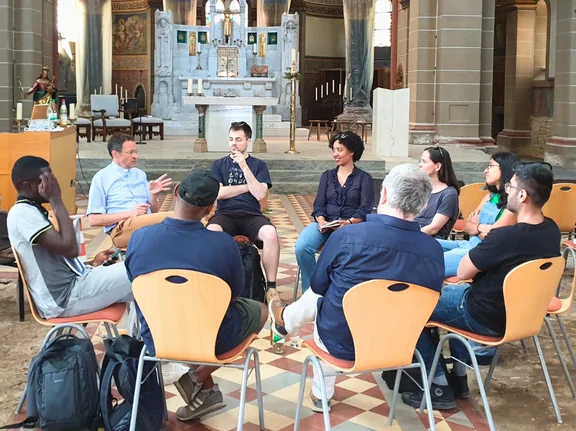 Maximilian Kranich stellt den Studierenden die Maßnahmen vor (Foto: UW/H I Angela John, Lea von Dömming) Maximilian Kranich im Sitzkreis mit Studierenden in der Kirche