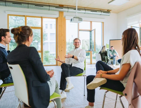 Teilnehmende eines Seminars sind im Gespräch.