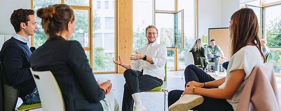 Teilnehmende eines Seminars sind im Gespräch.