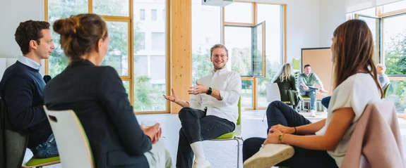 Teilnehmende eines Seminars sind im Gespräch.