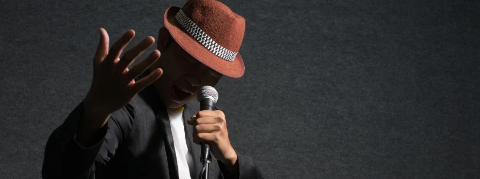 You see a musician holding a microphone and singing. 