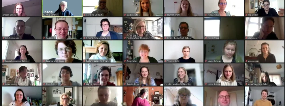 Aufnahme eines Zoom-Bildschirms, auf dem zahlreiche Personen in einzelnen Kacheln zu sehen sind.