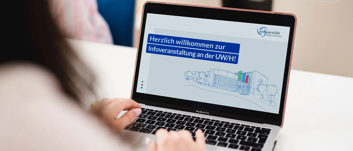 Screen eines Laptops, auf dem "Herzlich willkommen zur Infoveranstaltung an der UW/H" zu lesen ist 