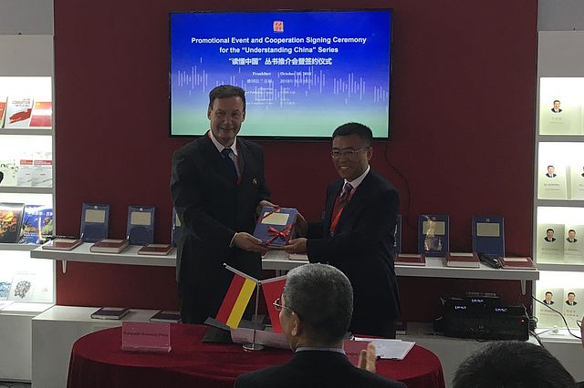 Vize-Amtsleiter Liu Dawei (chinesisches Fremdsprachenamt) überreicht UW/H-Forscher Martin Woesler ein Buchgeschenk.