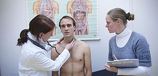 Studierende untersuchen einen Patienten 