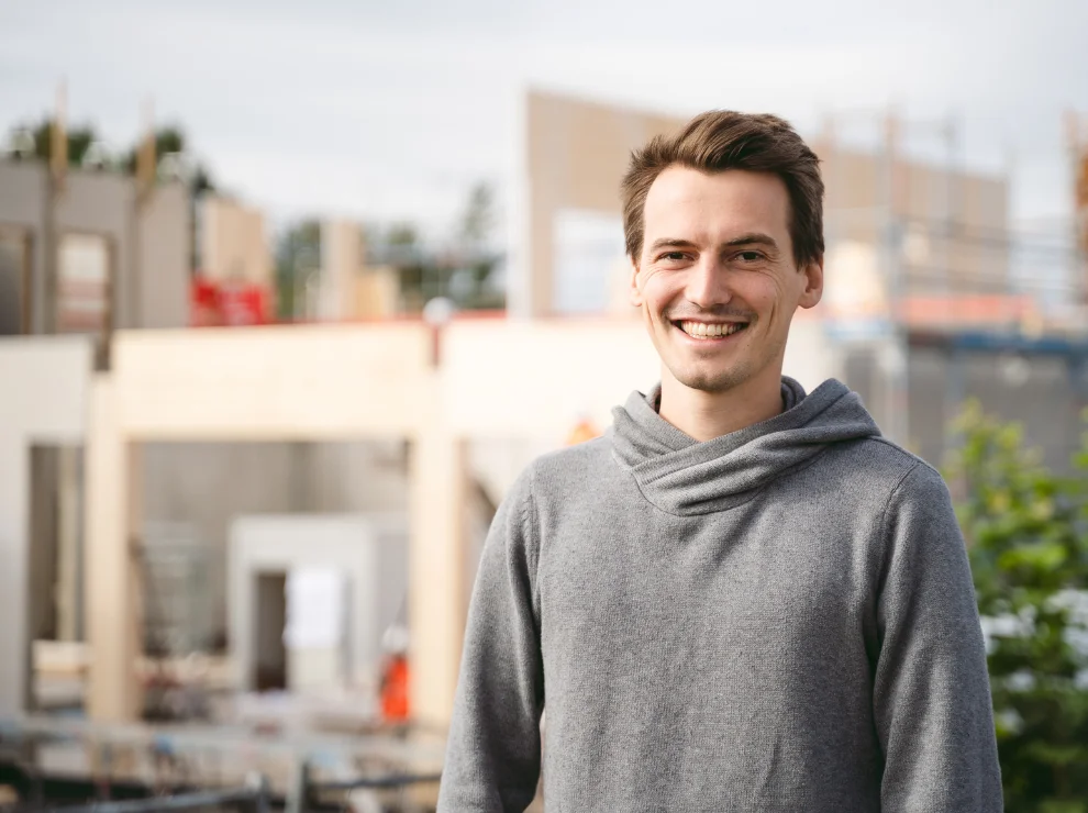 Dominik Treß vor der Baustelle des Holzgebäudes