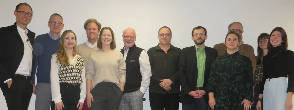 Eine Personengruppe lächelt in die Kamera.