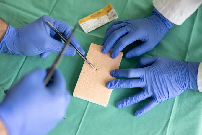 Students learn how to sew using practice material