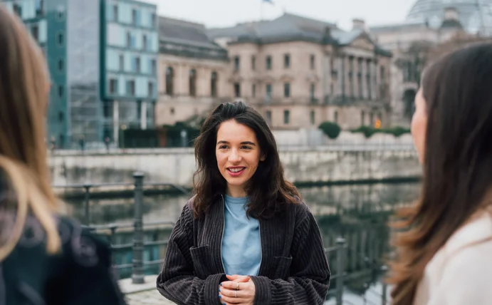 Portrait einer Frau. Im Hintergrund ist die Kuppel des Bundestags.