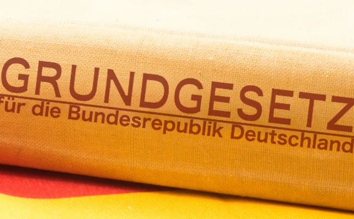 Ein Buch liegt seitlich auf einer Deutschlandflagge.