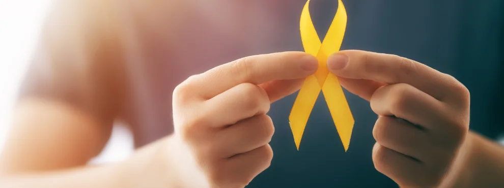 Zwei Hände halten eine goldene Schleife.