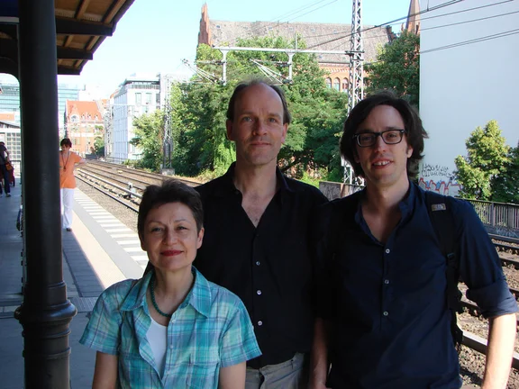 Three people smile into the camera.