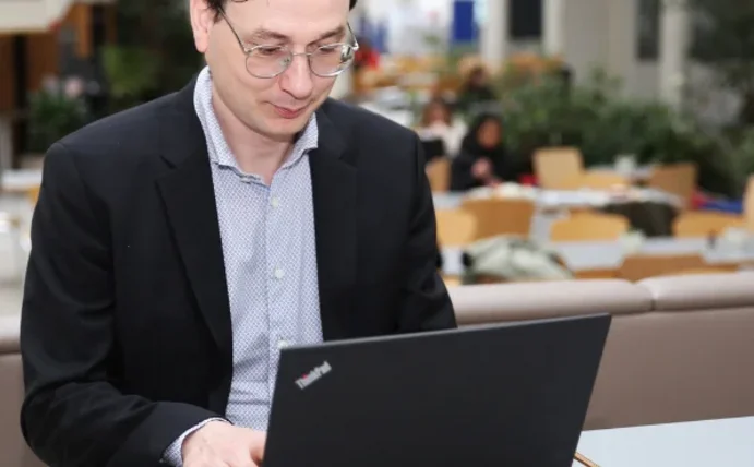 Prof. Dr. Lukas Stötzer sitzt an einem Laptop