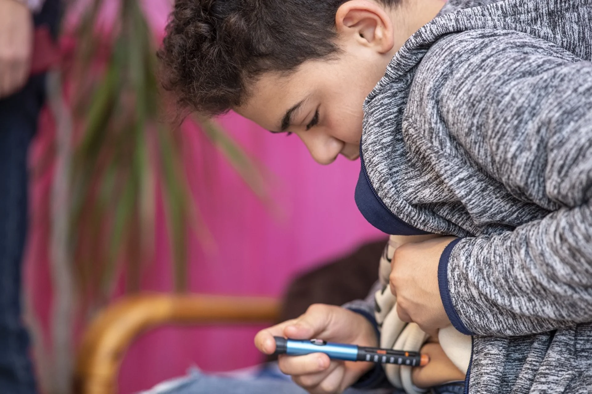 A boy injects himself in the stomach.